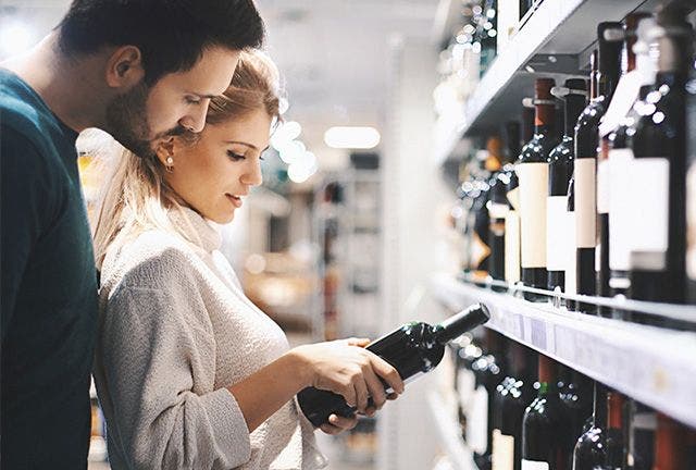 Woman and man reading wine bottle