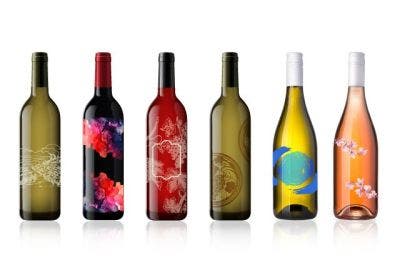 6 bottles ranging from green, yellow, to red colored wine bottles with unique designs on each one.